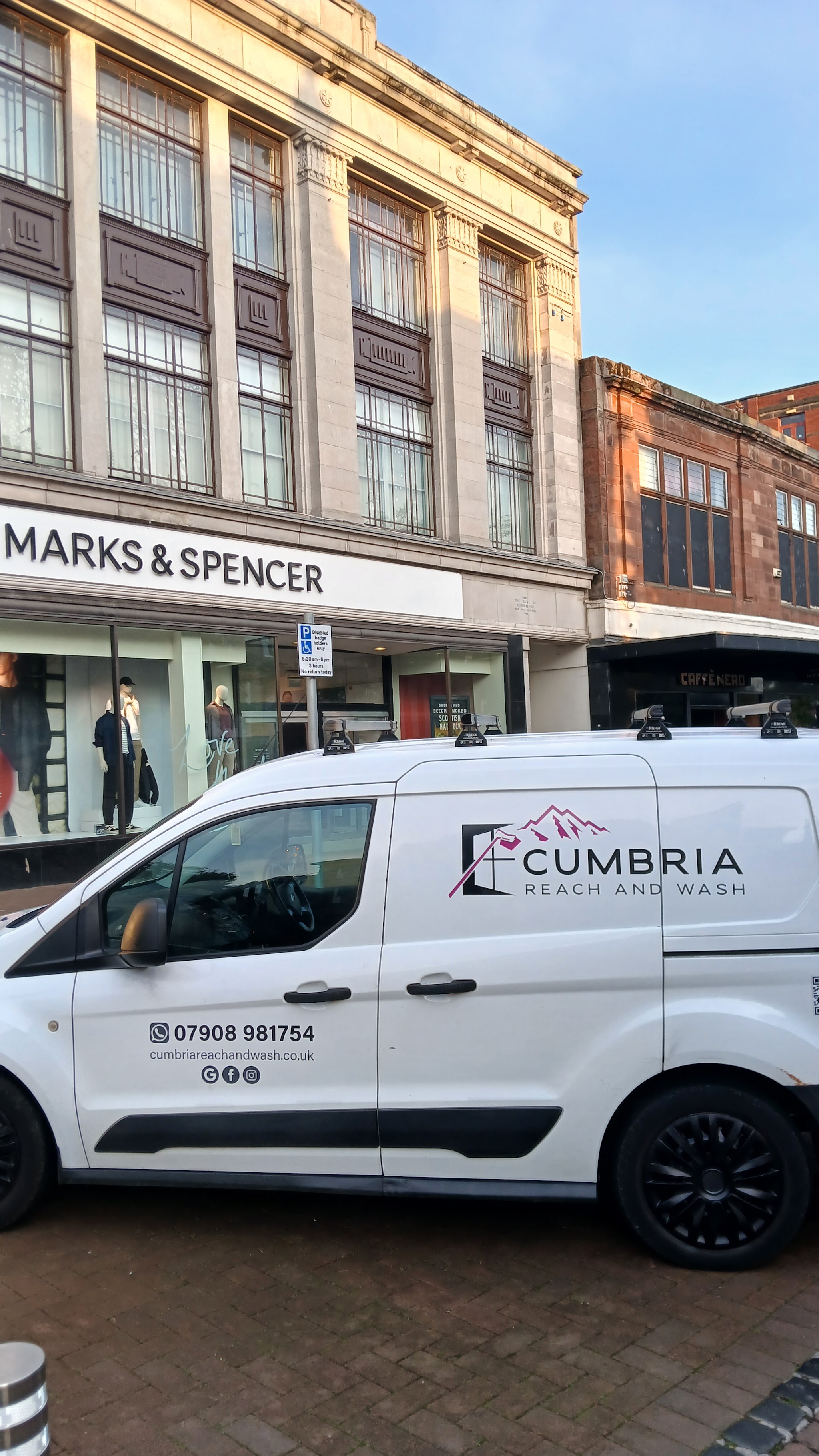 A Cumbria Reach and Wash van outside a high street shop